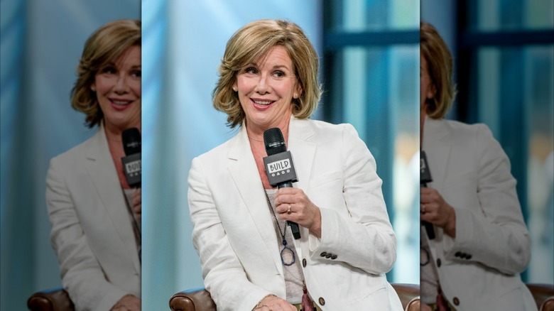 Melissa Gilbert habla por un micrófono con una chaqueta blanca