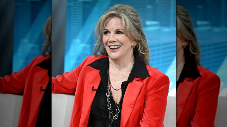 Melissa Gilbert sonríe luciendo un peinado voluminoso y un blazer rojo