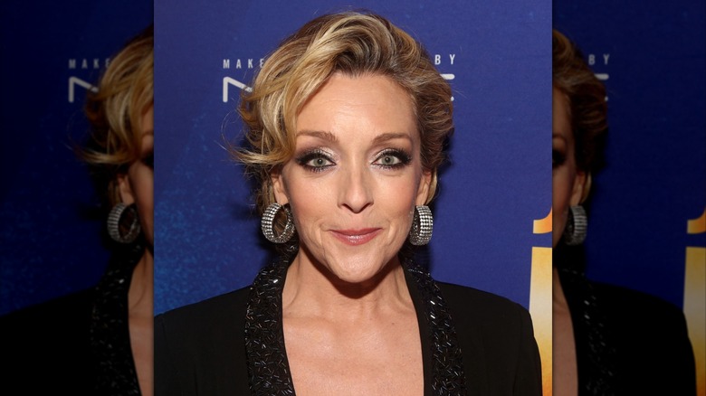 Jane Krakowski con un recogido rizado y grandes aretes llamativos
