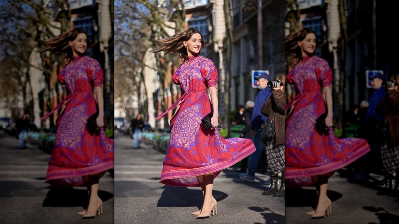 Una mujer con un vestido floral rosa y tacones nude.