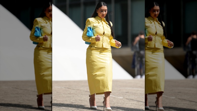 Una mujer con un vestido amarillo y una falda lápiz.