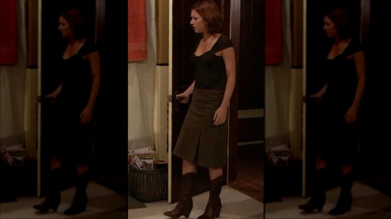 Lily Aldrin con falda larga marrón y botas camperas