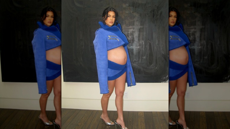 Kourtney Kardashian con conjunto azul de dos piezas que deja ver su barriga