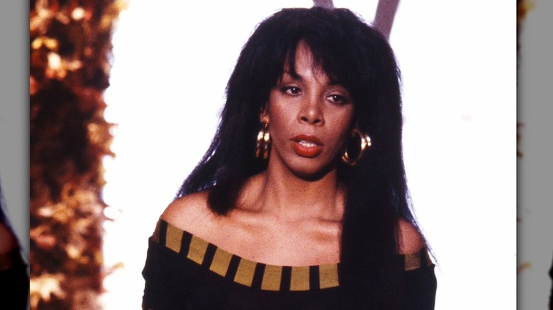 Donna Summer actúa con aros dorados y una falda dorada