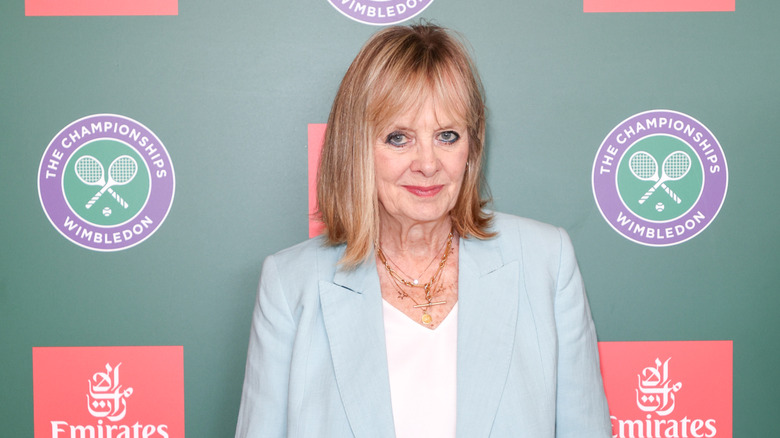 Twiggy posando en un evento en 2025 con un top blanco y una chaqueta azul claro.