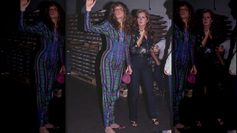 Carly Simon luciendo un mono a cuadros para una actuación, con Bonnie Raitt a su lado