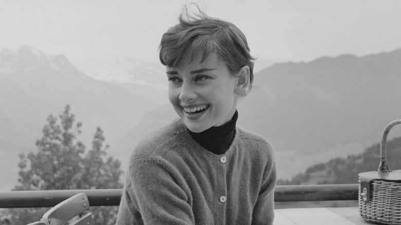 Fotografía en blanco y negro de Audrey Hepburn en un restaurante en la cima de una montaña en Suiza en 1955.
