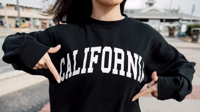 Una niña señala una sudadera negra con la palabra 