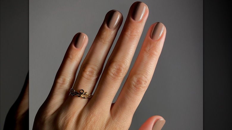 Mujer con uñas color burdeos