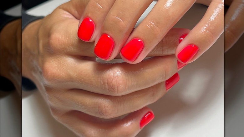 Mujer con uñas rojas brillantes