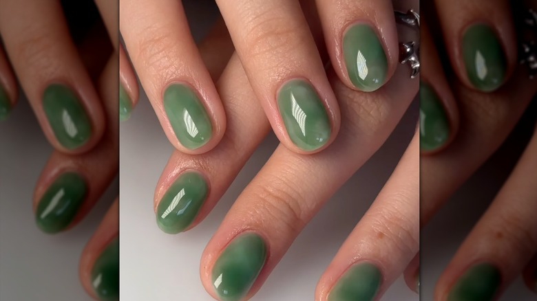 Mujer con manicura verde jade.