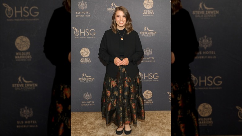 Bindi Irwin con un suéter negro con cuello alto y la parte delantera metida en una falda larga floral de corte A en la Gala Steve Irwin 2023