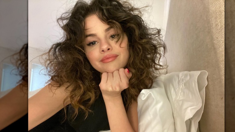Selena Gomez sonríe en una selfie en la cama
