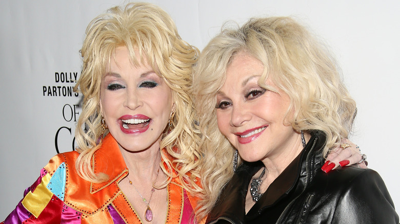 Dolly Parton se ríe mientras posa con su hermana Stella en la alfombra roja.