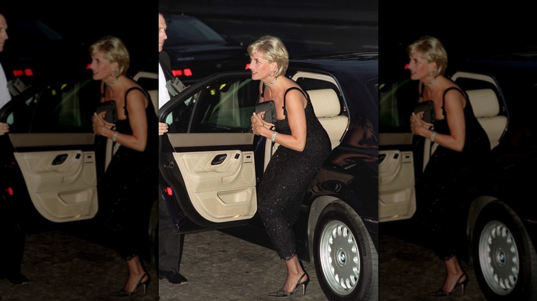 La princesa Diana sale de un auto con un bolso de mano negro contra su pecho.