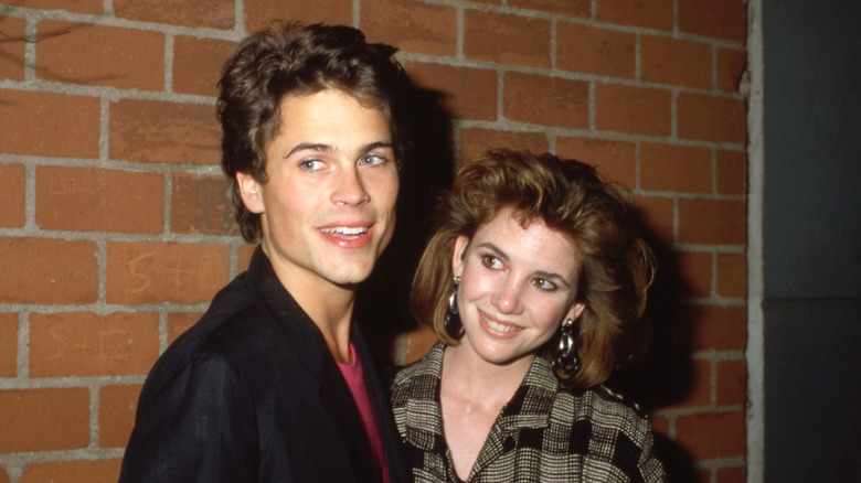 Los jóvenes Rob Lowe y Melissa Gilbert frente a una pared de ladrillos
