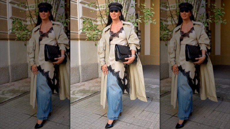 Una mujer coloca una combinación de encaje color canela y negro sobre unos jeans azules holgados en la Semana de la Moda de Milán en 2025.