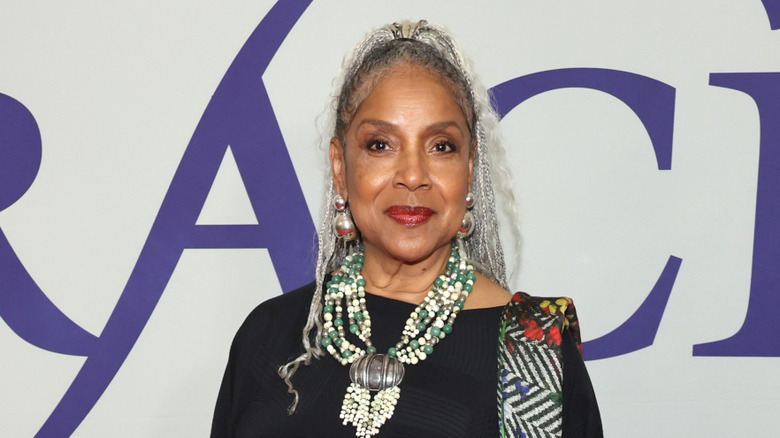 Phylicia Rashad sonríe con trenzas plateadas y luce un llamativo collar de cuentas