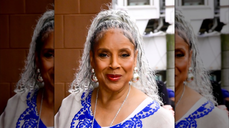 Phylicia Rashad con una túnica azul y blanca y el pelo trenzado