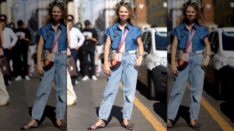 Una mujer que llevaba unos mom jeans de lavado claro y una camisa vaquera corta.