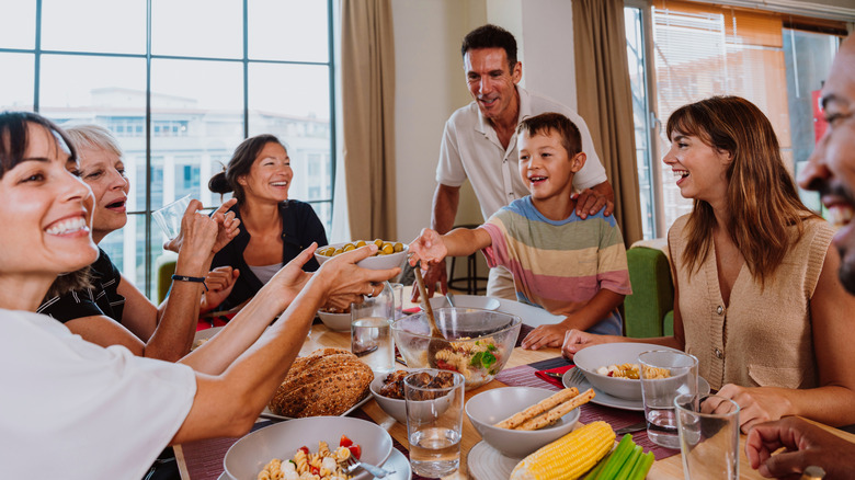 Familia feliz sentada alrededor de la mesa