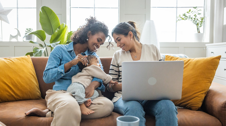 Dos mujeres sonriendo a un bebé