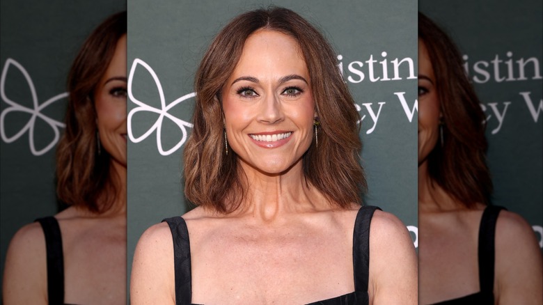 Nikki DeLoach sonríe con un vestido negro