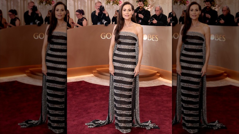 Minnie Driver en la alfombra roja de los Globos de Oro con un vestido de rayas negras y plateadas.