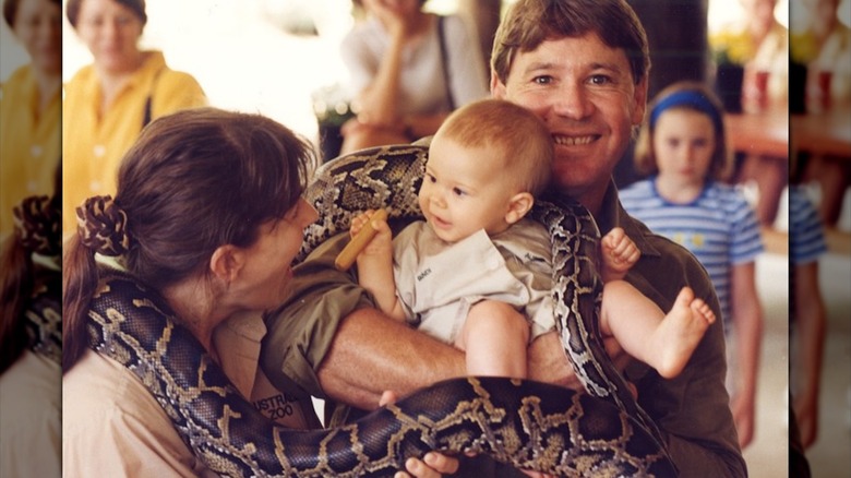 Steve Irwin y Bindi Irwin sostienen a Bindi Irwin mientras una pitón los envuelve
