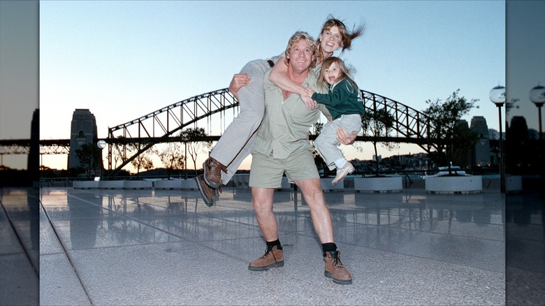 Steve Irwin sosteniendo a Terri Irwin y Bindi Irwin frente al Puente del Puerto de Sydney