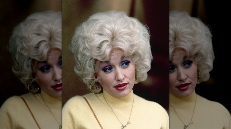 Dolly Parton con una peluca rubia y lápiz labial rojo