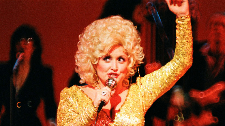 Dolly Parton con peluca inspirada en la permanente y mono dorado