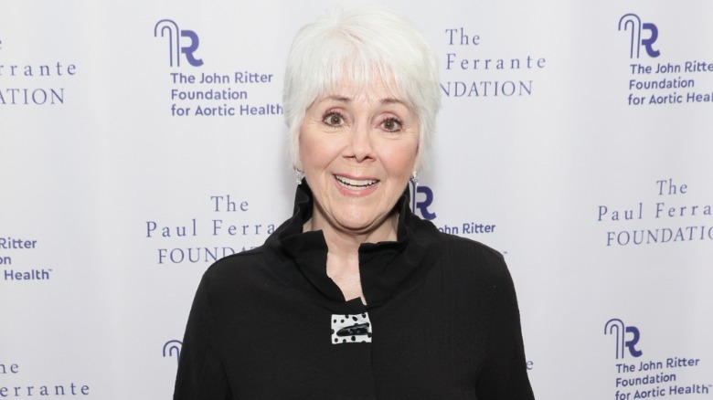 Joyce Dewitt luciendo un conjunto negro con el pelo corto y blanco.