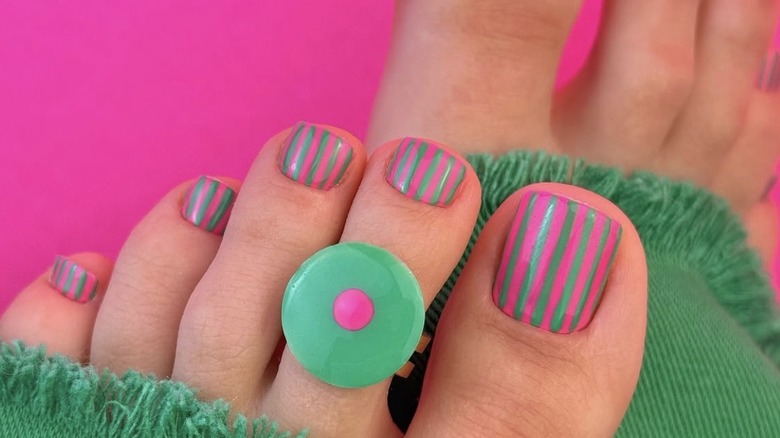 Pedicura a rayas turquesa y rosa fuerte