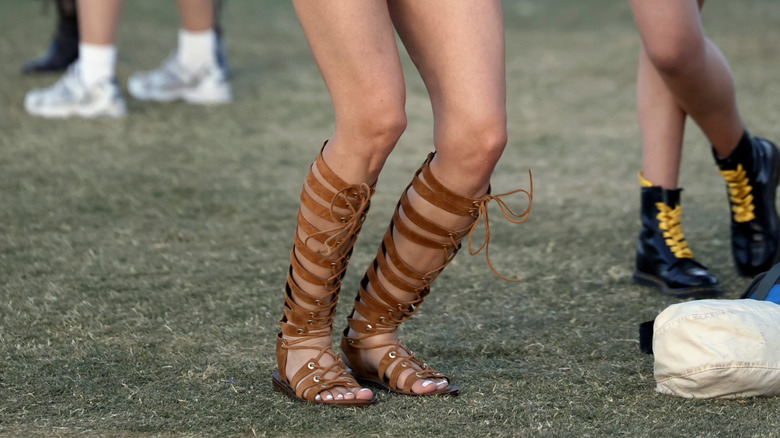 Primer plano de una mujer que llevaba sandalias de gladiador con cordones marrones