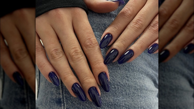 Una manicura almendrada con esmalte de uñas azul medianoche.