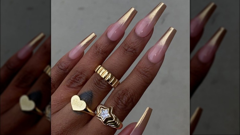 Una manicura francesa larga con puntas cromadas doradas.