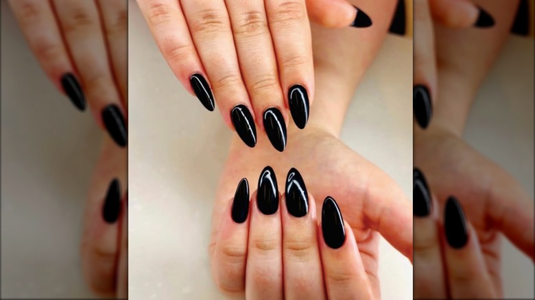 Una manicura almendrada con esmalte de uñas negro azabache.