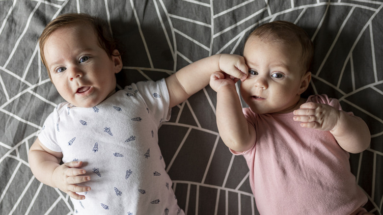 Un niño y una niña juntos sobre una manta