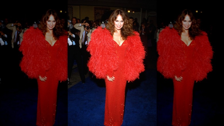 Catherine Bach sonríe con un vestido rojo de lentejuelas y una chaqueta de piel roja