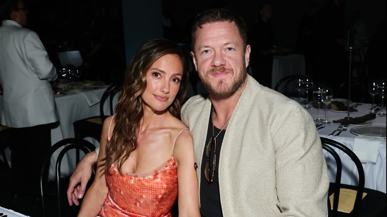 Minka Kelly y Dan Reynolds posan para una foto mientras están sentados juntos en una mesa de comedor
