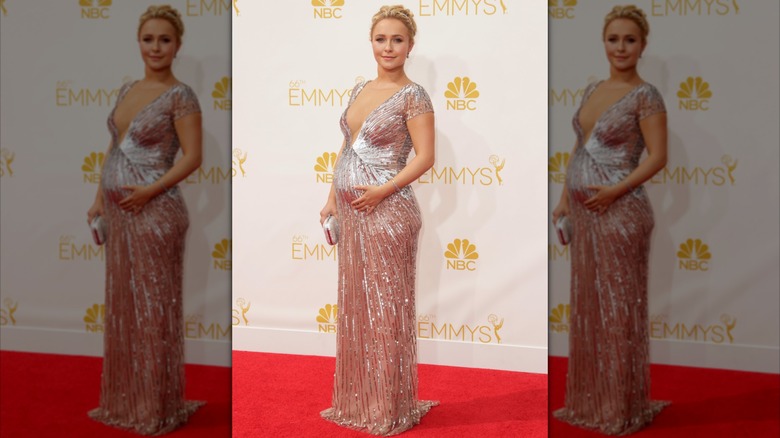 Hayden Panettiere posando con un etéreo vestido rosa plateado con panza en agosto de 2014.