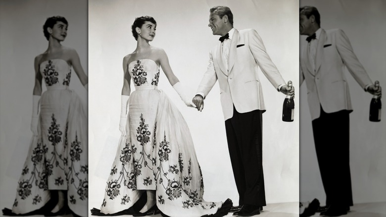 Folleto publicitario de la película de 1954, "Sabrina." En esta recreación de estudio de una de las escenas de la película, Audrey Hepburn y William Holden interpretan al patito feo convertido en reina de belleza Sabrina Fairchild y al encantador playboy millonario Linus Larrabee, respectivamente.