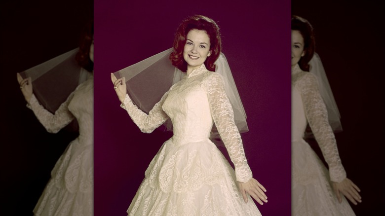 Shelley Fabares posa con un vestido de novia de encaje y velo corto para un retrato de 1965.