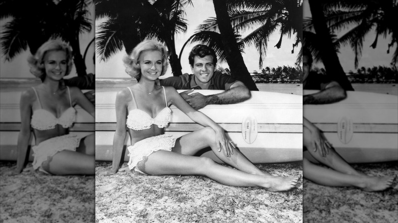 Shelley Fabares en bikini blanco y Fabián posando junto a una tabla de surf en foto promocional de 
