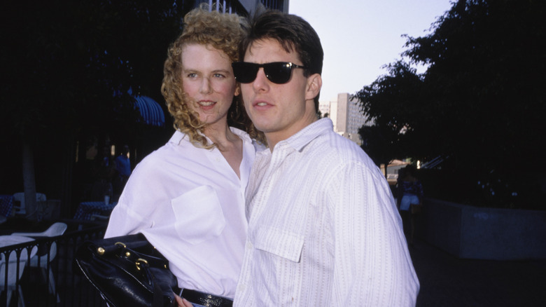 Nicole Kimdan posando con Tom Cruise en 1990, ambos vestidos con camisas blancas con botones.