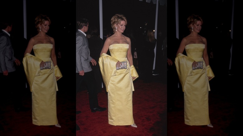 Deidre Hall sonríe con un vestido sin tirantes de color amarillo mantequilla y un chal.
