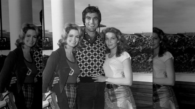 Deidre Hall (izquierda) sonríe con un cárdigan junto a Tom Selleck (centro) y Jaime Lyn Bauer (derecha).
