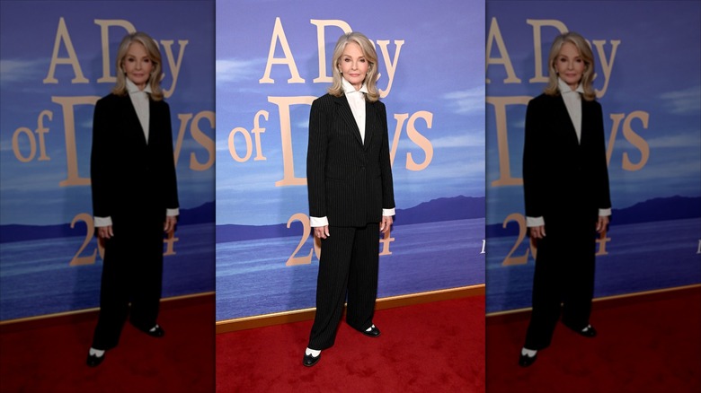 Deidre Hall sonríe con un traje a rayas