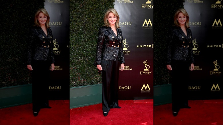 Deidre Hall sonríe con una chaqueta negra con incrustaciones